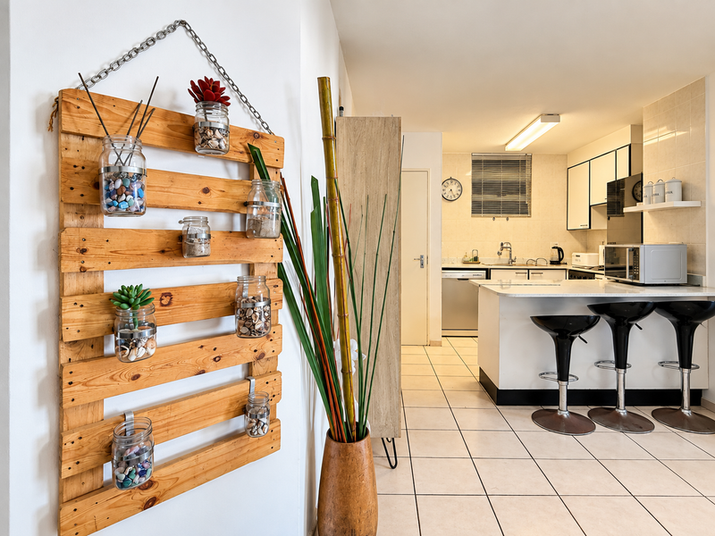 Open plan kitchen area featuring tiled flooring, white cabinetry, and a breakfast bar island, providing a functional and bright cooking and dining space.