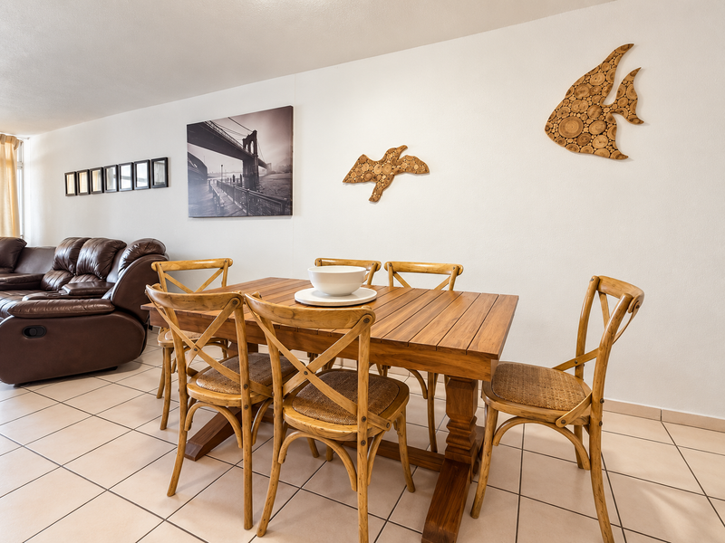A living and dining area featuring neutral ceramic floor tiles and a spacious layout suitable for comfortable family living.