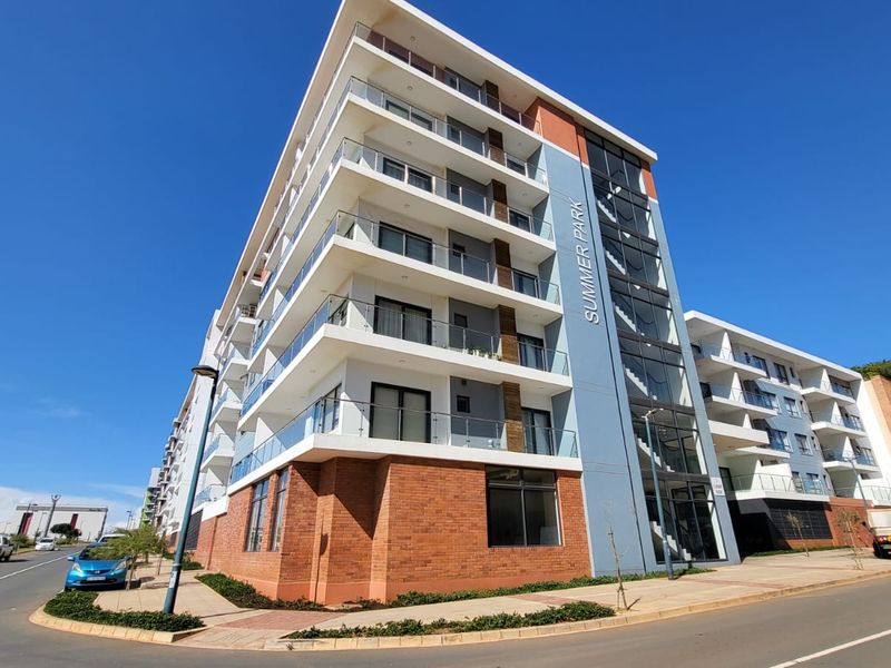 Modern multi-story apartment building featuring a contemporary brick and glass facade with private balconies and a prominent stairwell design.