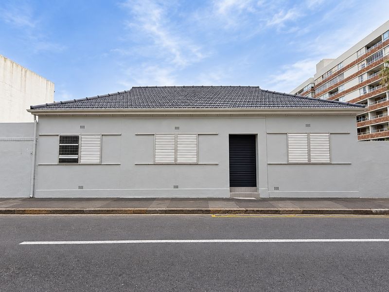 Front facade of a single-story property featuring a tiled roof, secure window shutters, and a gated entrance directly accessible from the street.
