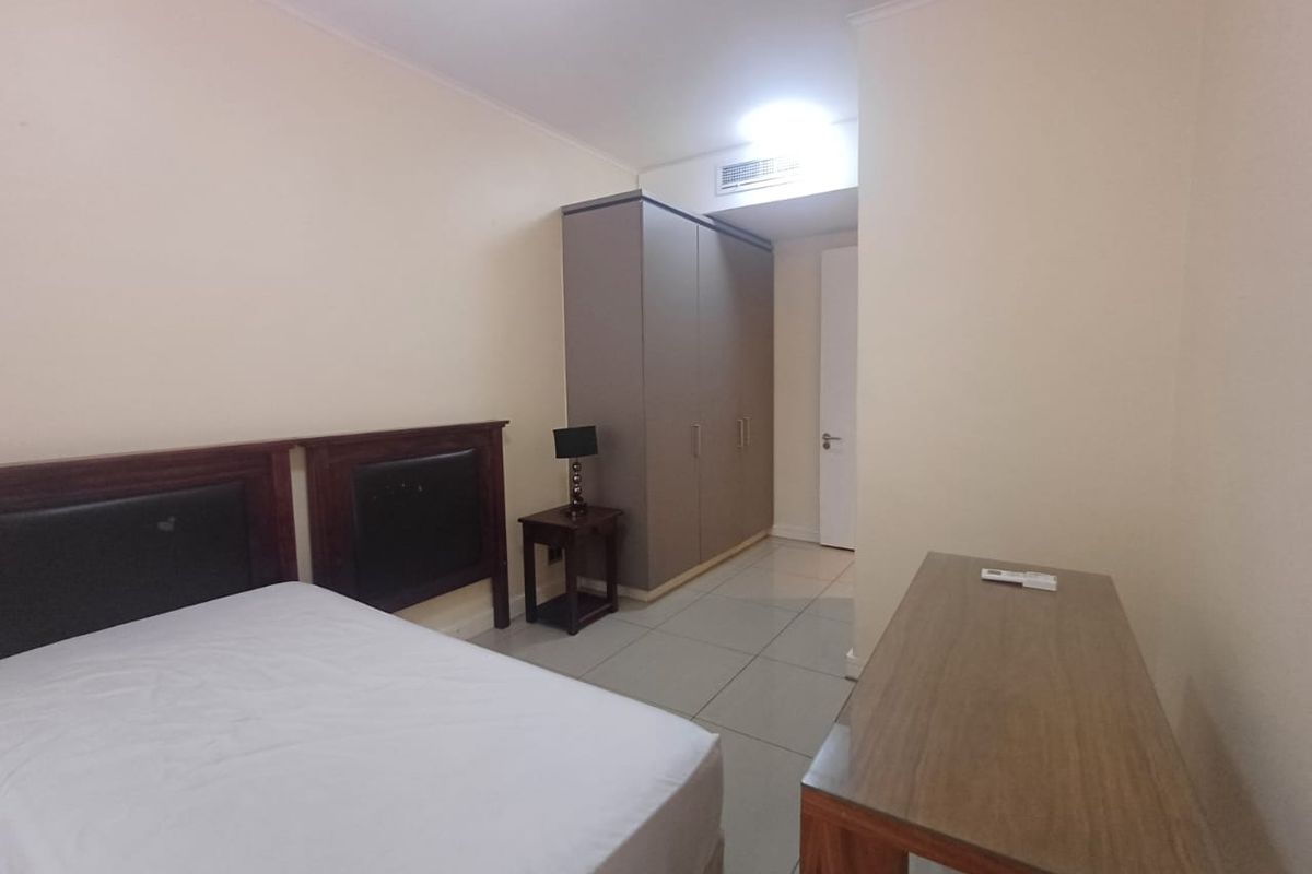 A functional bedroom featuring tiled flooring, a built-in wardrobe, and integrated ducted air conditioning.