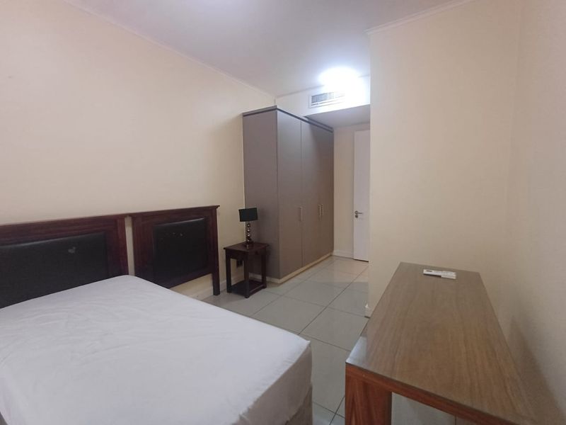 A functional bedroom featuring tiled flooring, a built-in wardrobe, and integrated ducted air conditioning.