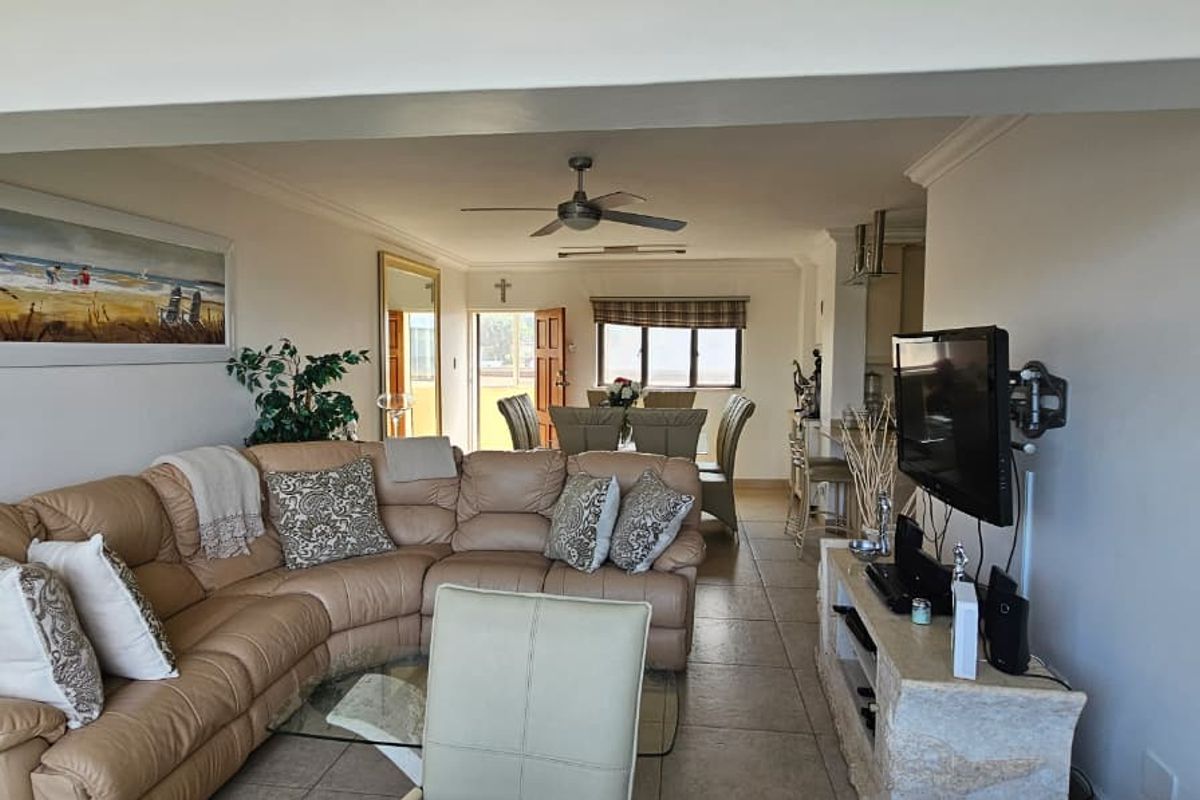 Spacious open-plan living and dining area featuring tiled flooring and a ceiling fan, creating a comfortable and functional layout for daily living.