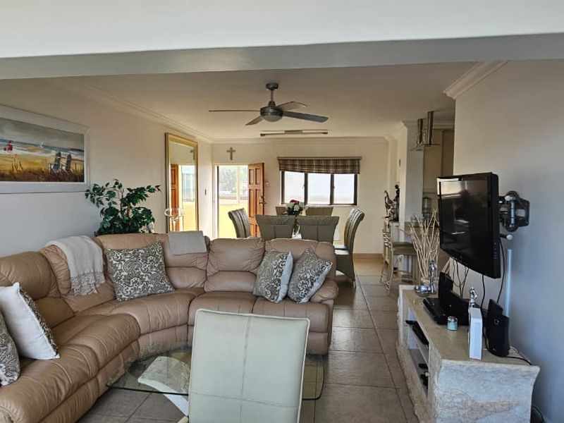 Spacious open-plan living and dining area featuring tiled flooring and a ceiling fan, creating a comfortable and functional layout for daily living.