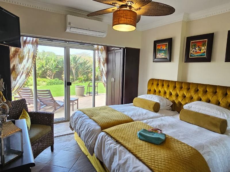 A well-maintained bedroom featuring tiled floors, a ceiling fan, split-system air conditioning, and sliding glass doors providing direct access to an outdoor patio area.