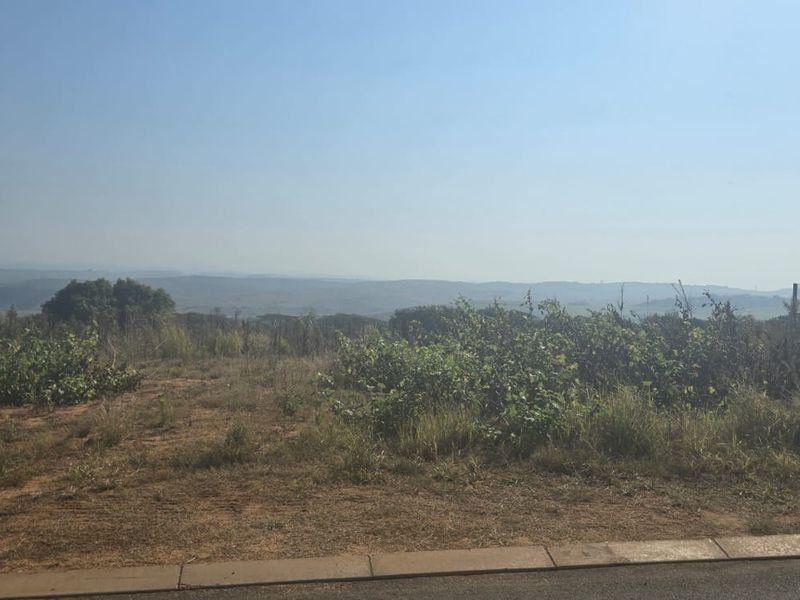A wide-angle view of the vacant residential land, showcasing the natural landscape and surrounding terrain.