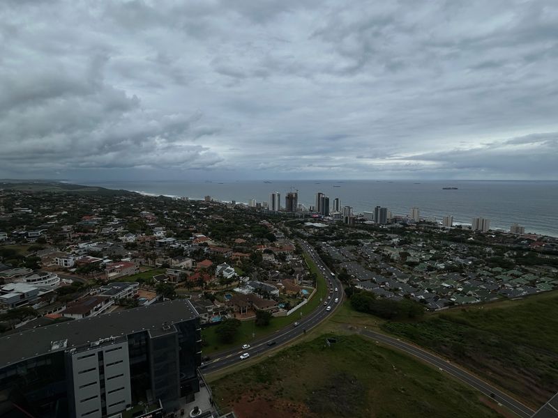 An elevated aerial view showcasing the coastal landscape, surrounding residential neighborhood, and proximity to the ocean.