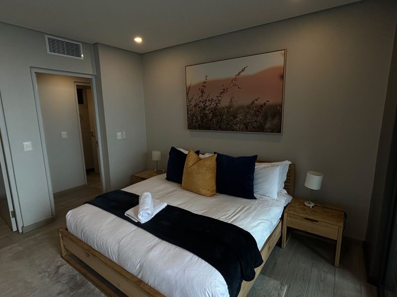 Modern bedroom featuring tiled flooring, recessed lighting, and integrated ducted air conditioning, with direct access to an en-suite bathroom.