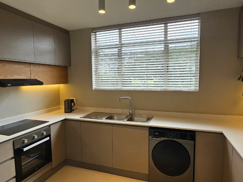 Modern, well-appointed kitchen featuring sleek cabinetry, stone countertops, integrated appliances, and ample under-cabinet lighting, creating a functional and contemporary culinary space.