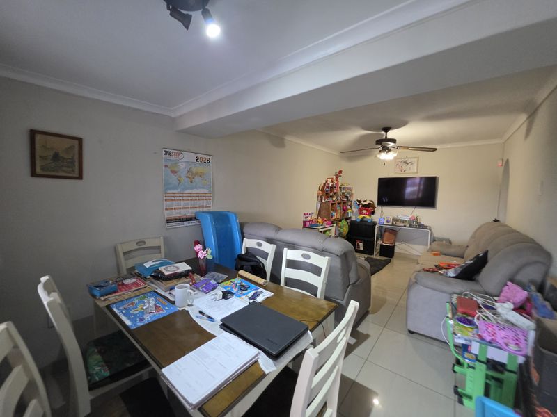 Open plan living and dining area featuring tiled flooring and a ceiling fan, providing a versatile space for family living.