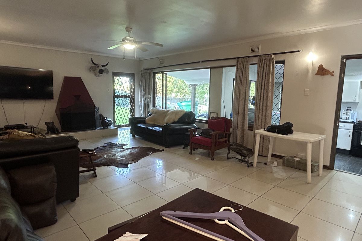 Spacious living room featuring tiled flooring, a built-in fireplace, and large sliding glass doors providing access to the outdoor area.