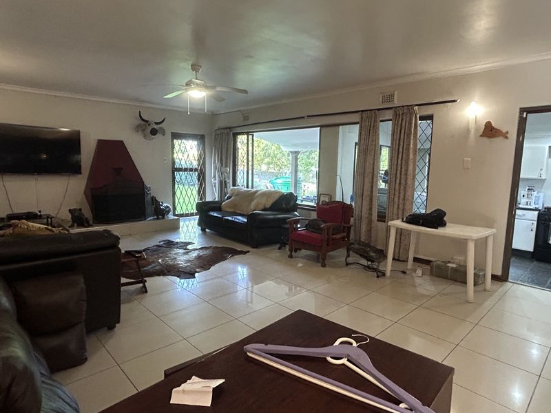Spacious living room featuring tiled flooring, a built-in fireplace, and large sliding glass doors providing access to the outdoor area.