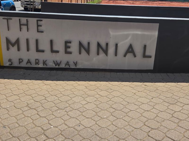 Entrance signage for The Millennial apartment complex located at 5 Park Way, featuring a paved driveway approach.