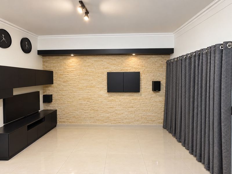 Modern living room featuring a stone accent wall, built-in cabinetry, tiled flooring, and elegant cornicing, creating a sophisticated and well-maintained space.