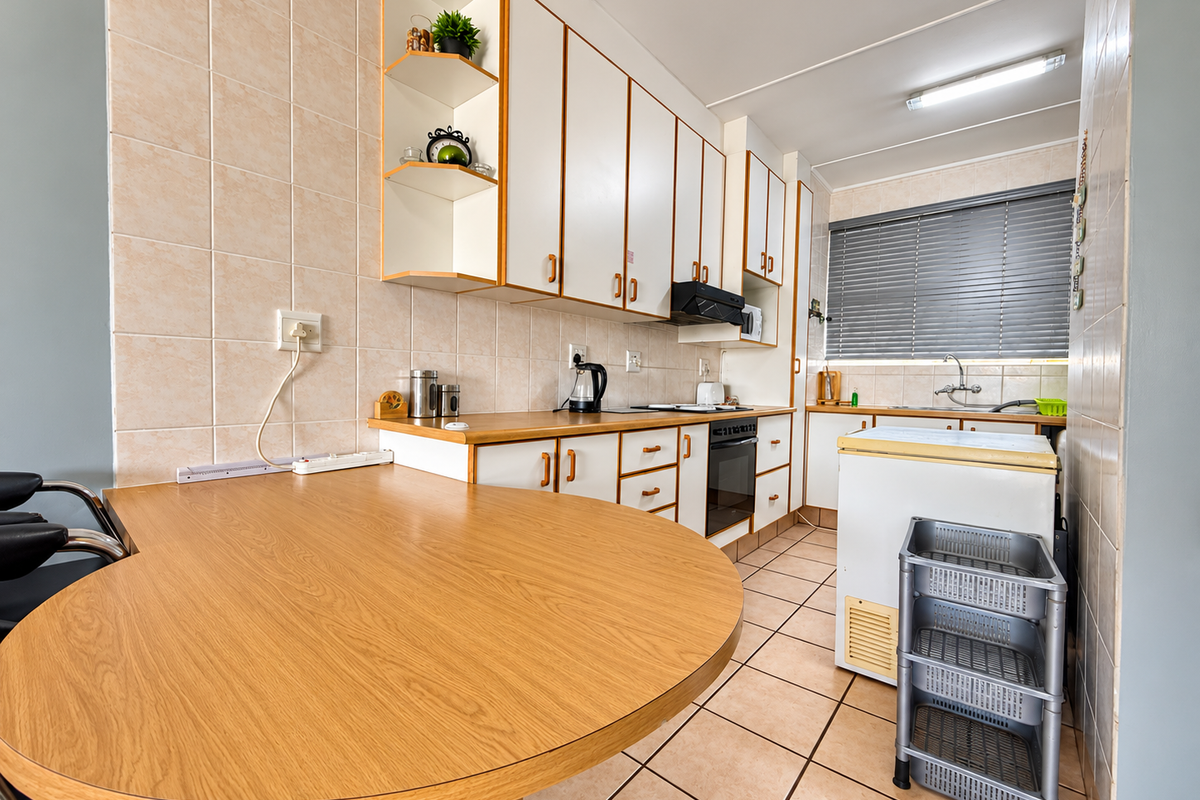 A functional kitchen featuring built-in cabinetry, laminate countertops, a built-in oven, and ceramic tile finishes throughout.