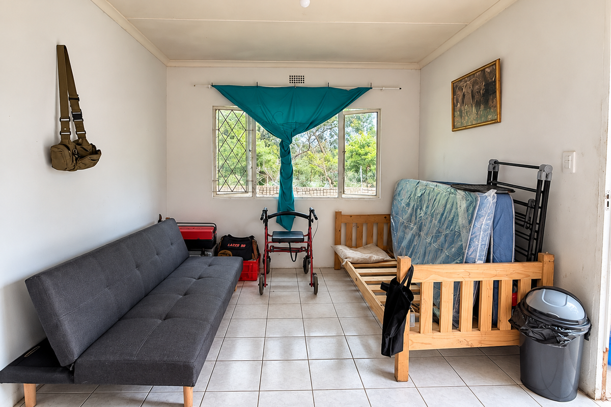 A bedroom featuring tiled flooring and security bars on the windows, currently used as a multi-purpose living space.