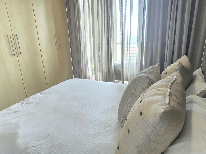 A well-maintained bedroom featuring built-in cupboards and a sliding door providing access to an outdoor area.