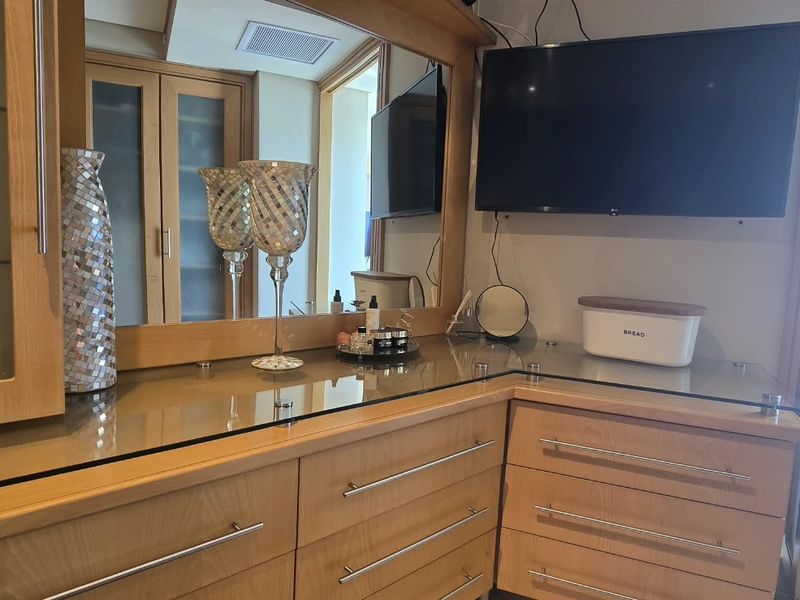 Bedroom featuring extensive built-in wooden cabinetry with integrated mirror and storage drawers, providing ample organizational space.