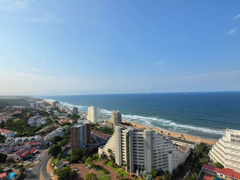 A panoramic aerial view showcasing the coastal landscape, oceanfront, and surrounding urban development.