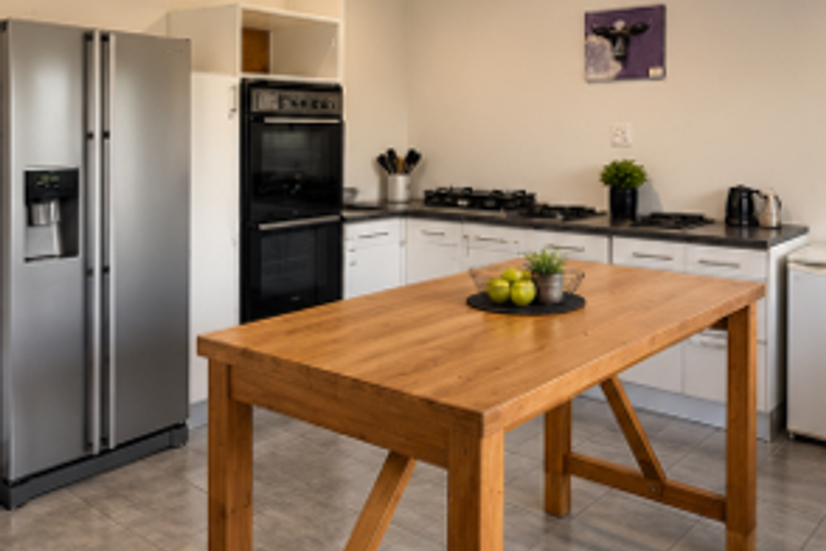 A functional kitchen featuring a built-in double oven, gas hob, laminate countertops, and tiled flooring, providing a practical workspace.