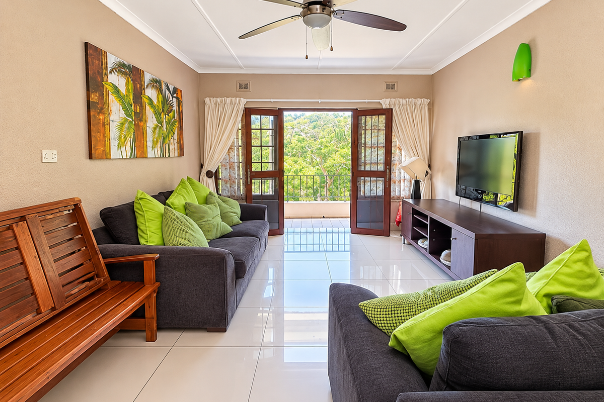A bright and well-maintained living room featuring polished tiled floors, a ceiling fan, and double doors opening onto a balcony with scenic views.