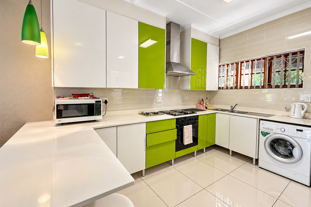 Modern kitchen featuring high-gloss white and lime green cabinetry, stone countertops, integrated appliances, and tiled finishes throughout.