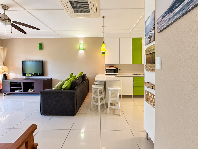 Open plan living and kitchen area featuring tiled flooring, modern cabinetry, breakfast bar, and integrated ducted air conditioning.
