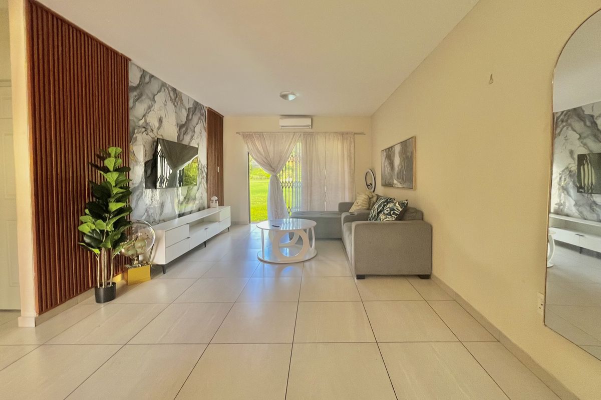 Modern living room featuring a stylish marble-look feature wall, vertical timber slats, tiled flooring, and direct access to an outdoor area via sliding doors.