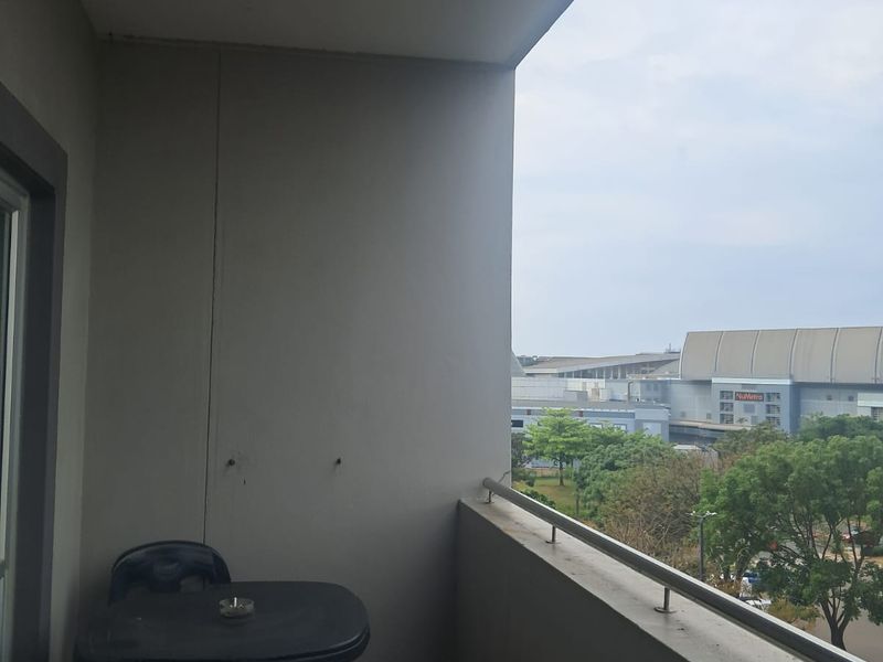 A covered balcony featuring tiled flooring and a metal balustrade, offering an elevated view of the surrounding area.