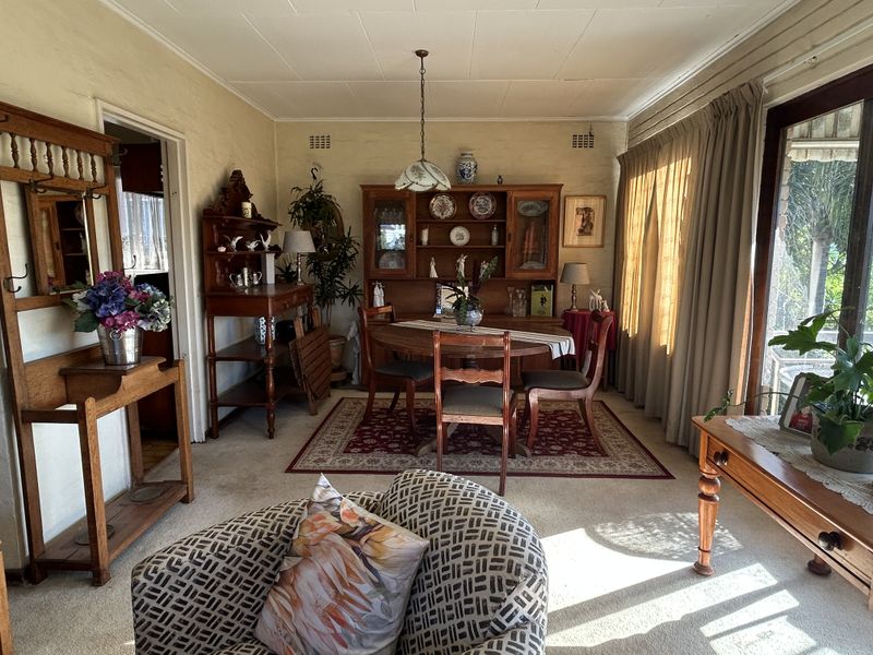 A traditional dining room featuring a built-in display cabinet, carpeted flooring, and sliding glass doors providing access to the exterior.