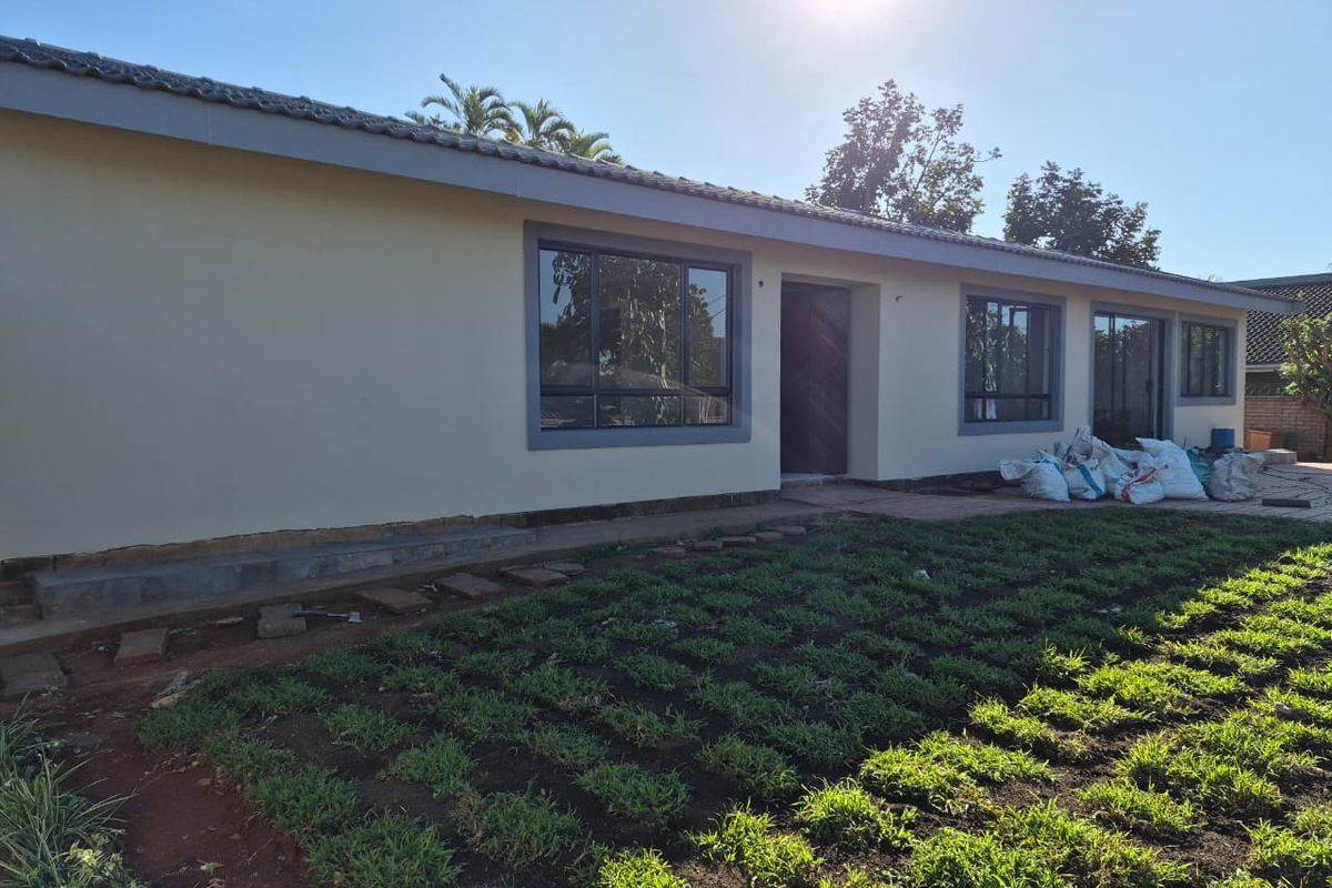 Rear view of the house featuring a tiled roof, aluminium window frames, and a garden area currently under development.
