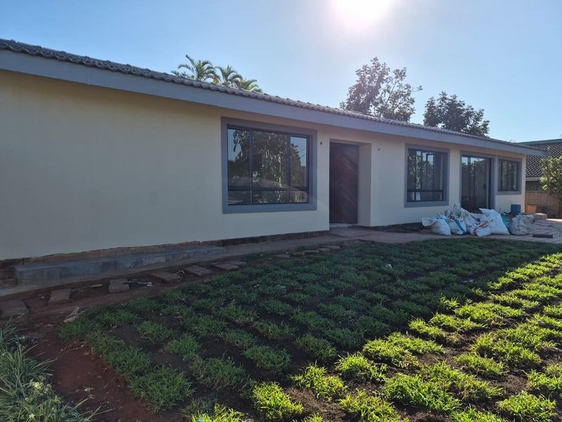 Rear view of the house featuring a tiled roof, aluminium window frames, and a garden area currently under development.