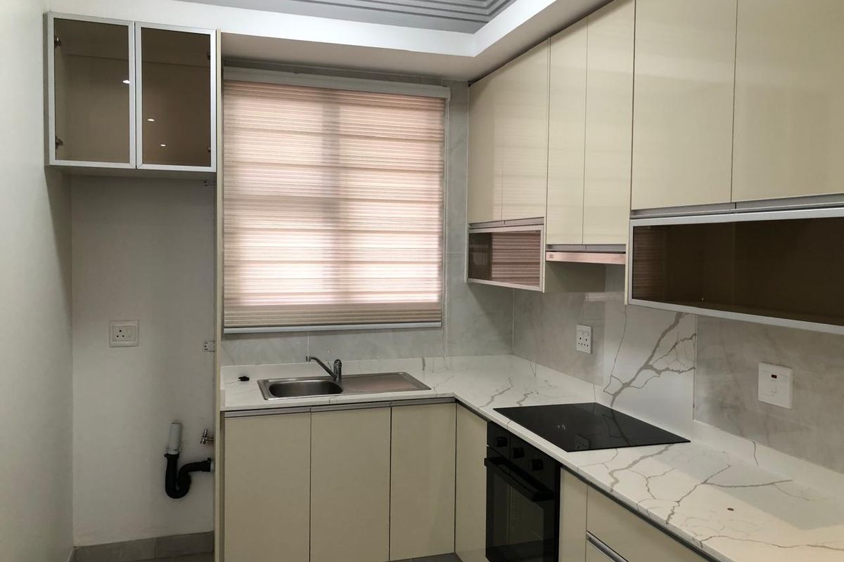 Modern kitchen featuring high-gloss cabinetry, stone countertops with marble-effect backsplash, integrated oven, and hob, offering a clean and functional culinary space.