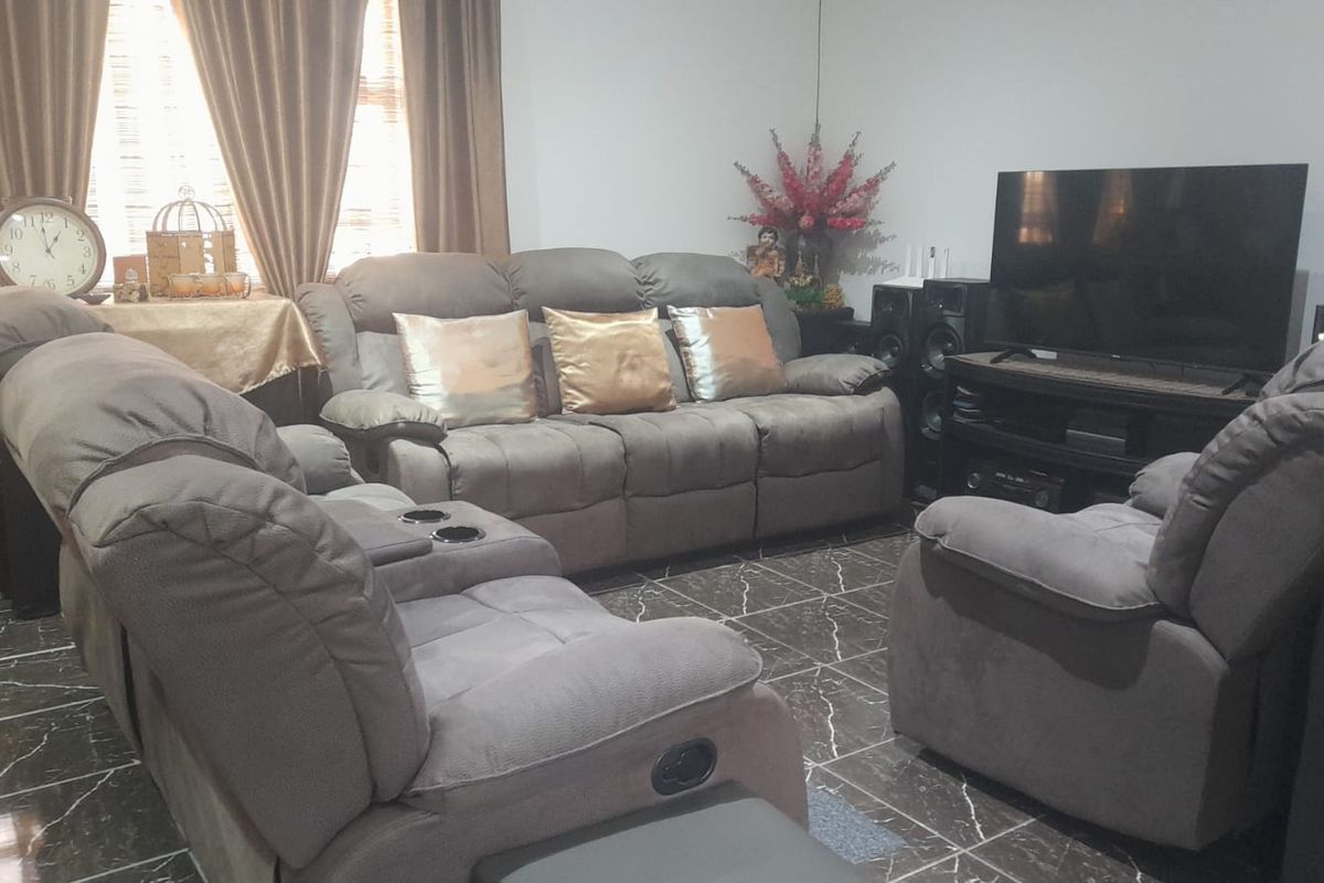 A comfortable living room featuring dark marble-effect tiled flooring and neutral wall finishes, providing a functional space for relaxation.