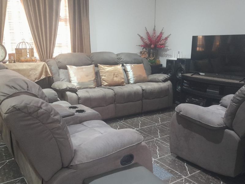 A comfortable living room featuring dark marble-effect tiled flooring and neutral wall finishes, providing a functional space for relaxation.