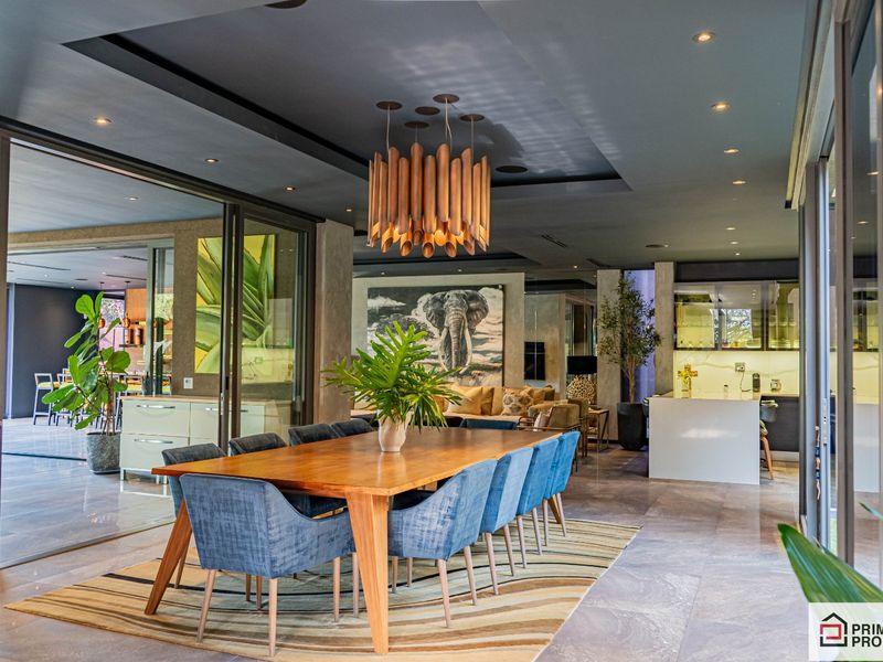 Spacious open-plan dining and living area featuring modern recessed ceiling lighting, large sliding glass doors, and high-quality tiled flooring throughout.