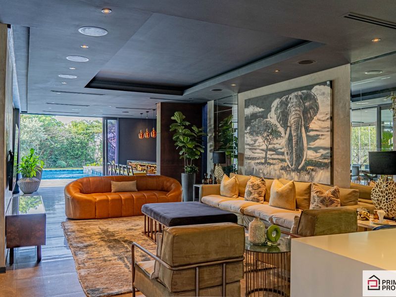 Spacious open-plan living area featuring recessed ceiling lighting, integrated speakers, and seamless flow to an outdoor patio and pool area.
