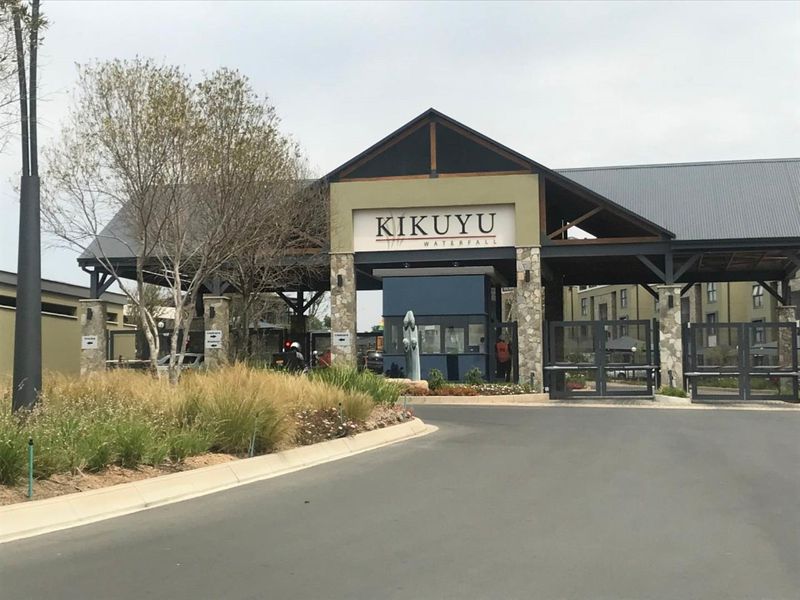 The main entrance and security gatehouse of the Kikuyu Waterfall apartment complex, featuring modern architectural design and controlled access.