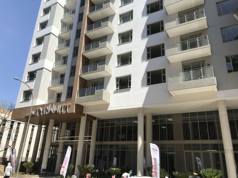 Modern apartment building facade featuring glass balustrades, private balconies, and large windows, showcasing contemporary architectural design and clean exterior finishes.