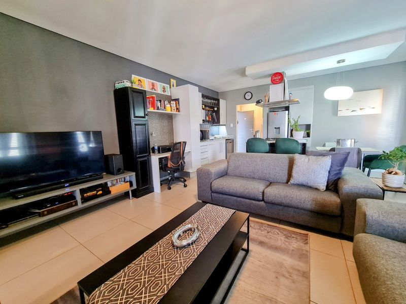 Open-plan living area featuring a modern kitchen with built-in cabinetry, integrated appliances, and a seamless flow into the lounge and dining space.