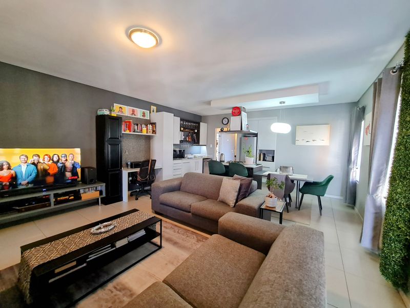 Open-plan living area featuring a modern kitchen with built-in cabinetry, integrated appliances, and a seamless flow into the dining and lounge space.