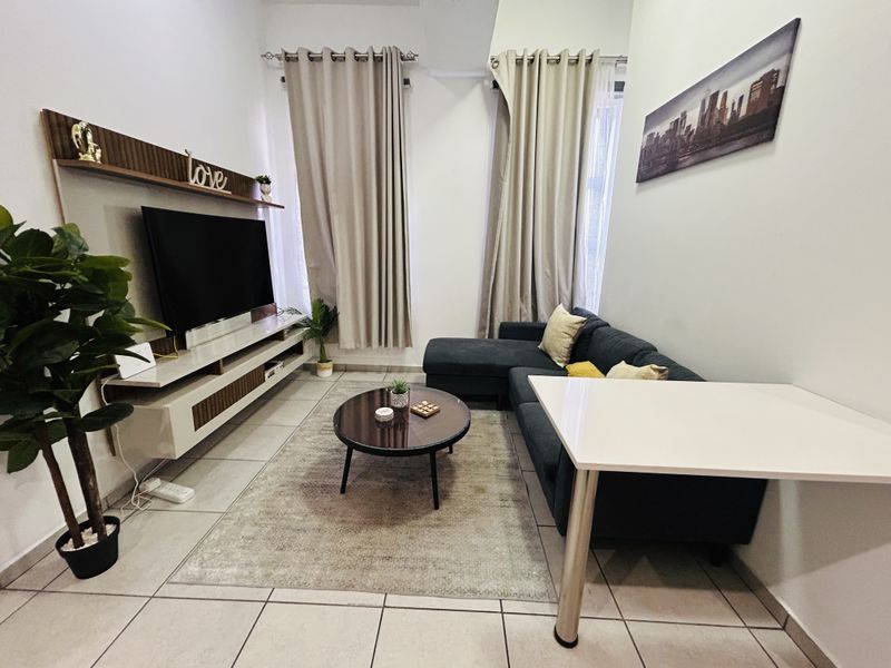 A well-maintained living room featuring tiled flooring and a built-in media console, offering a comfortable and functional space.