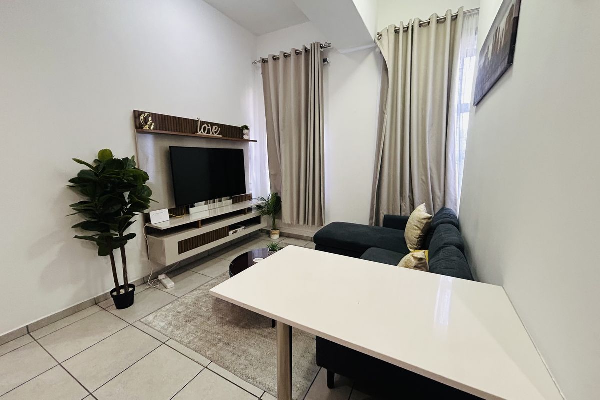 A well-maintained living room featuring tiled flooring and a built-in media console, offering a functional and comfortable space.