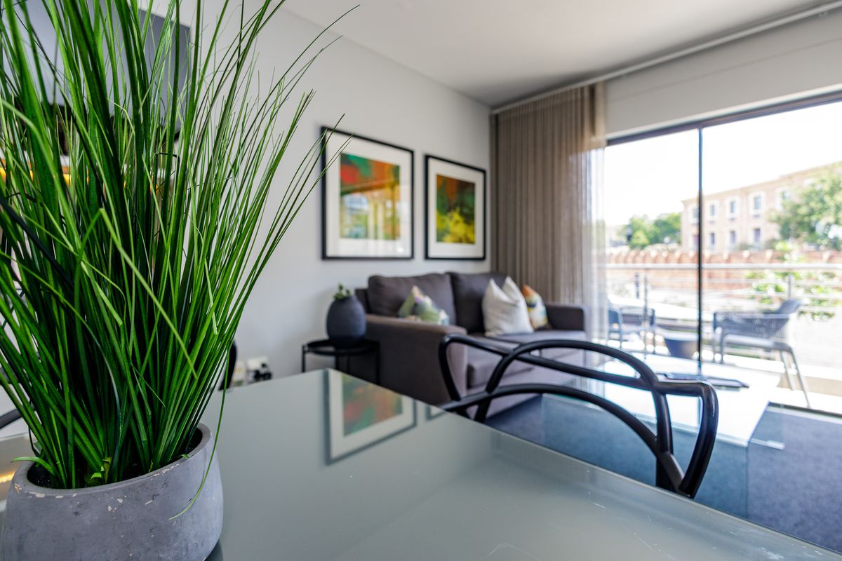 A bright living area featuring large sliding glass doors that open onto a balcony, providing natural light and a seamless transition to outdoor space.