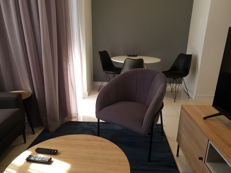 A well-maintained living area featuring tiled flooring and neutral wall finishes, providing a comfortable and functional space.