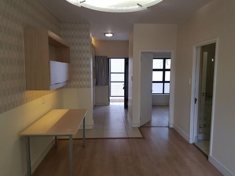 A functional hallway area featuring a mix of tiled and laminate flooring, built-in cabinetry, and access to adjacent rooms.
