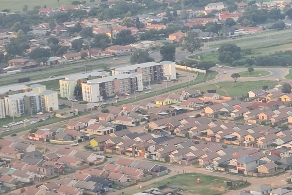 An aerial view of a residential neighborhood featuring a dense collection of suburban houses and apartment complexes.