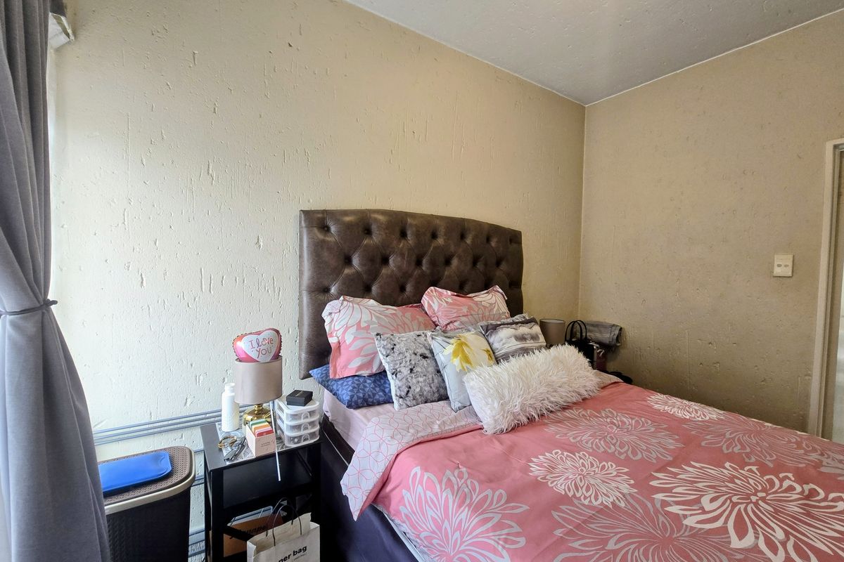 A bedroom featuring textured wall finishes and a neutral color palette, providing a functional space for rest.