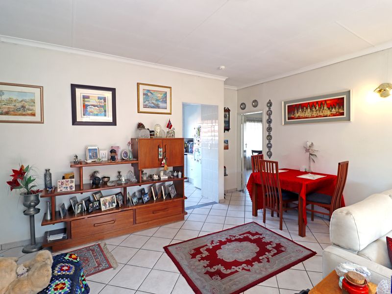 Open plan living and dining area featuring ceramic floor tiles and neutral wall finishes, providing a functional space for daily living.
