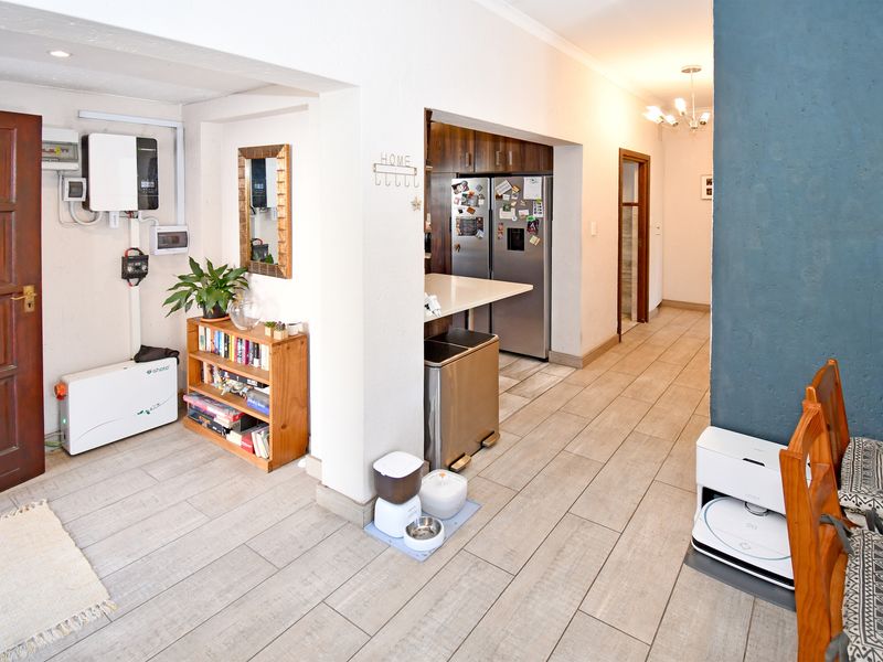 Open-plan living area featuring tiled flooring, recessed lighting, and a functional kitchen space with a breakfast counter and integrated solar power infrastructure.